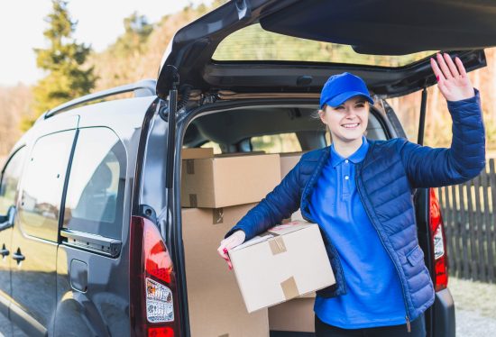 woman delivery driver with parcels in car along with DeliveryDart logo