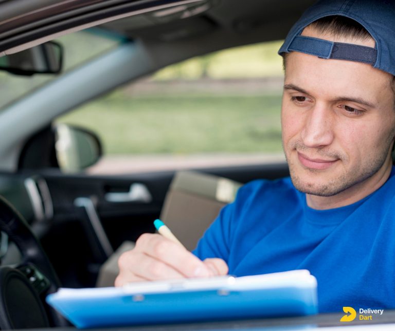 delivery driver sitting in a car filling forms with the DeliveryDart logo