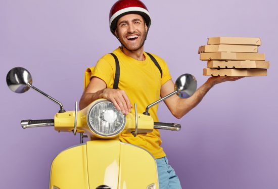 pizza delivery driver holding pizza boxes sitting on scooter with DeliveryDart logo