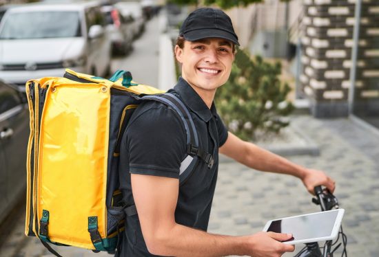 food delivery driver on duty sitting on a bike with a yellow bag and tablet along with the DeliveryDart logo