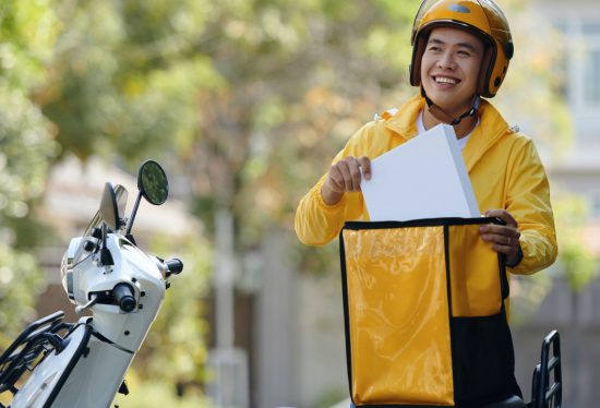 delivery driver putting delivery box into bag with DeliveryDart logo