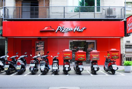 a pizza hut outlet with delivery bikes outside along with the DeliveryDart logo