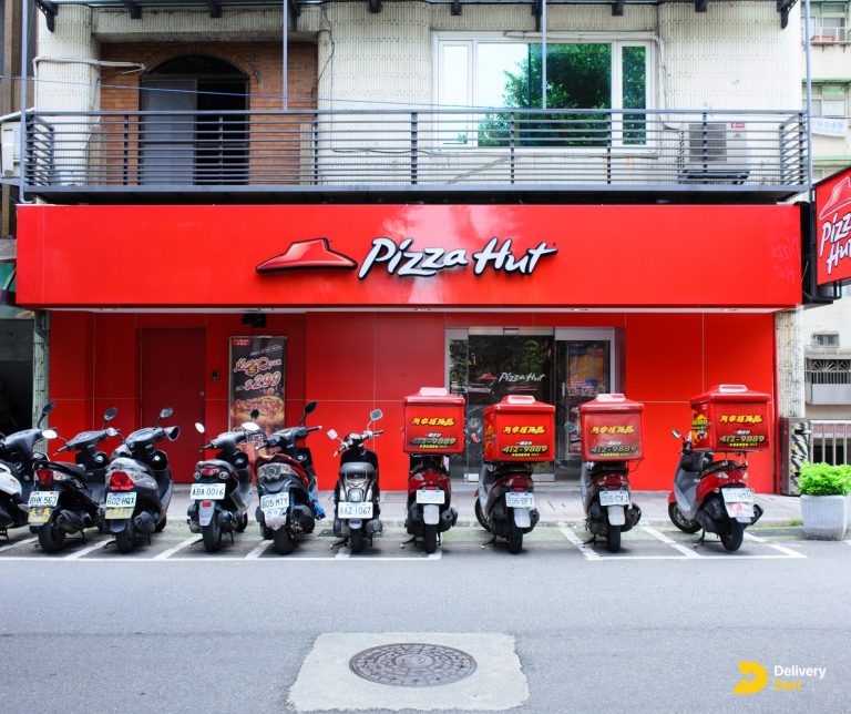 a pizza hut outlet with delivery bikes outside along with the DeliveryDart logo