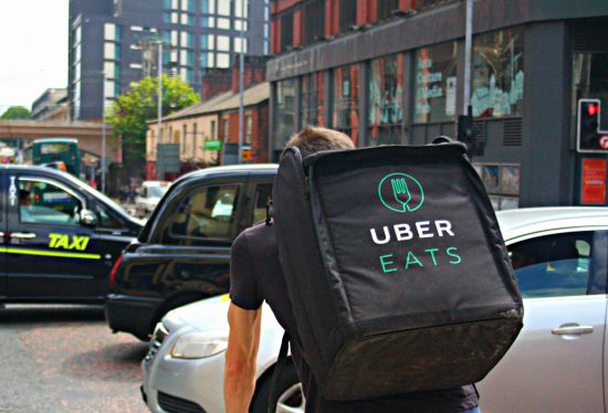 uber eats delivery driver on his way to delivery food along with the deliverydart logo