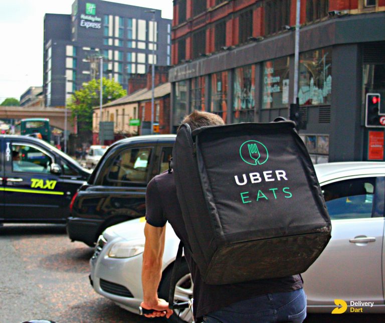 uber eats delivery driver on his way to delivery food along with the deliverydart logo