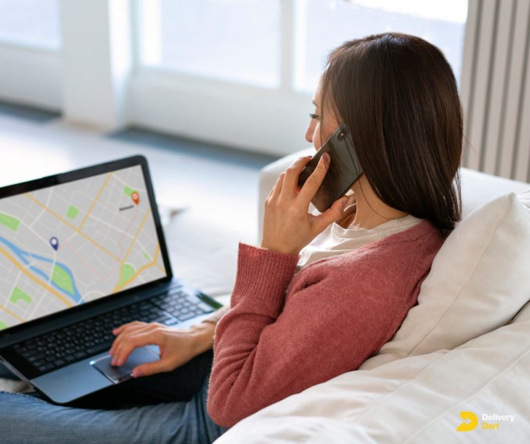 business woman checking gps tracker on laptop with DeliveryDart logo